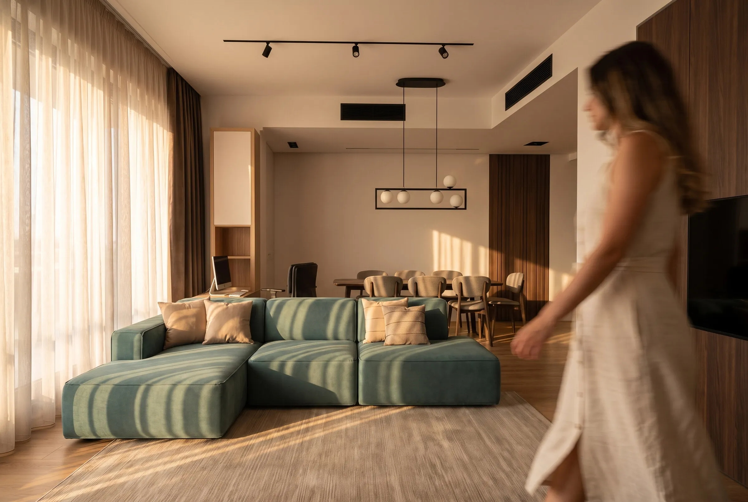 Living room: stripes of sunlight on the sofa, the owner walking past