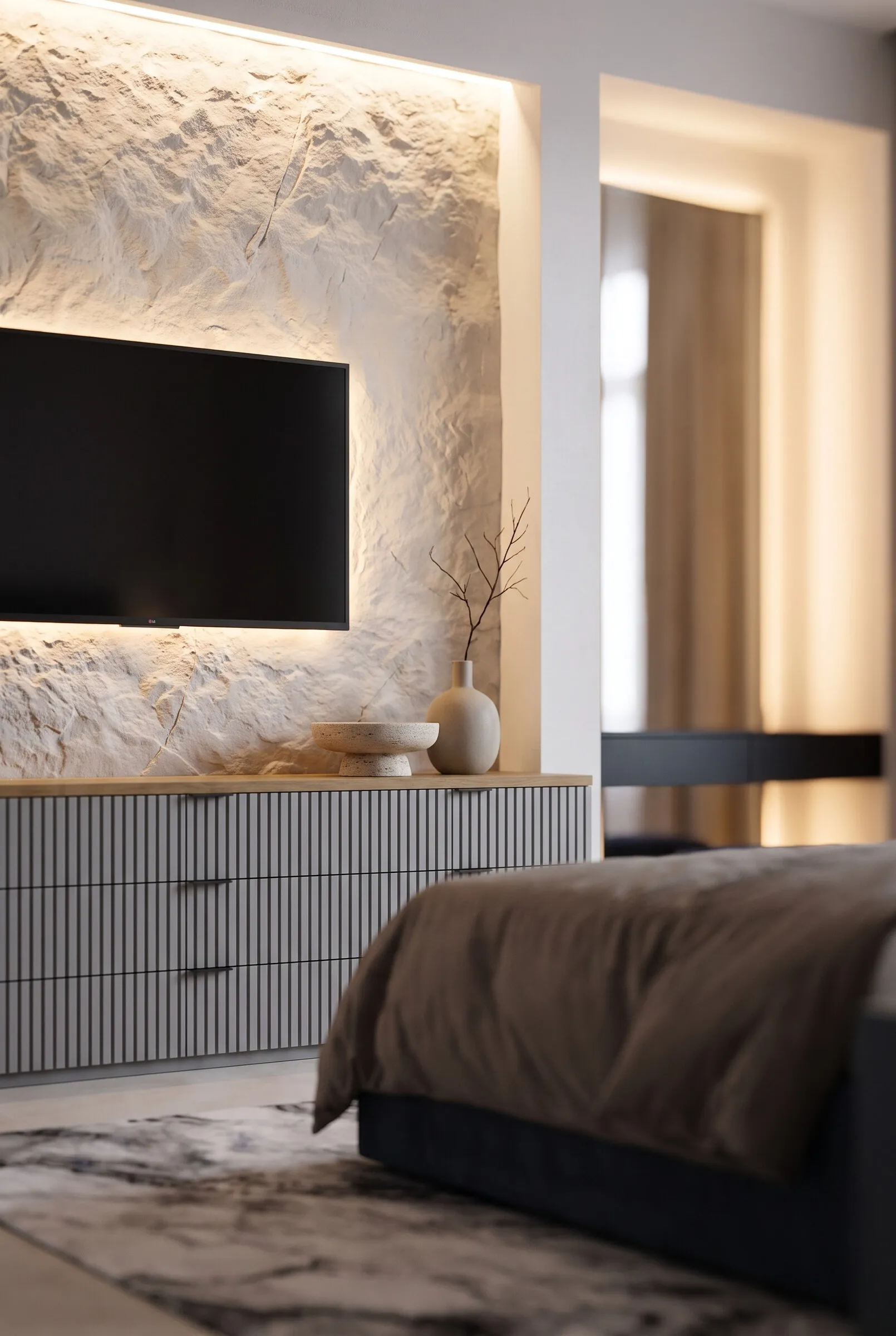 Bedroom: backlit stone TV wall and a chest of drawers